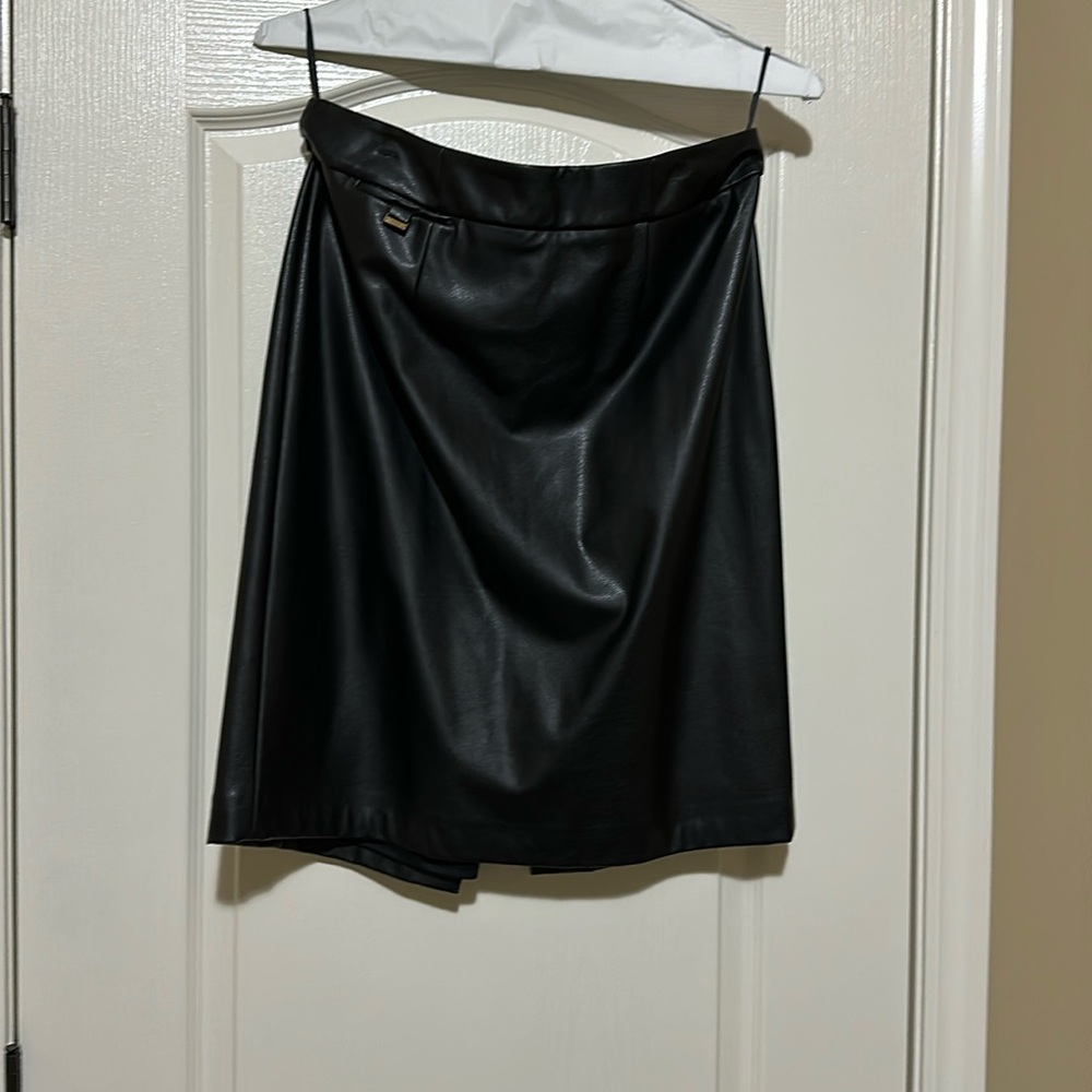 Black Calvin Klein Faux Leather Skirt w/Back Slit, Length 23 inches.